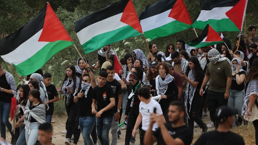 Arab-Israeli protesters wave Palestinian national flags during a rally near Israel's northern city of Shefa Amr