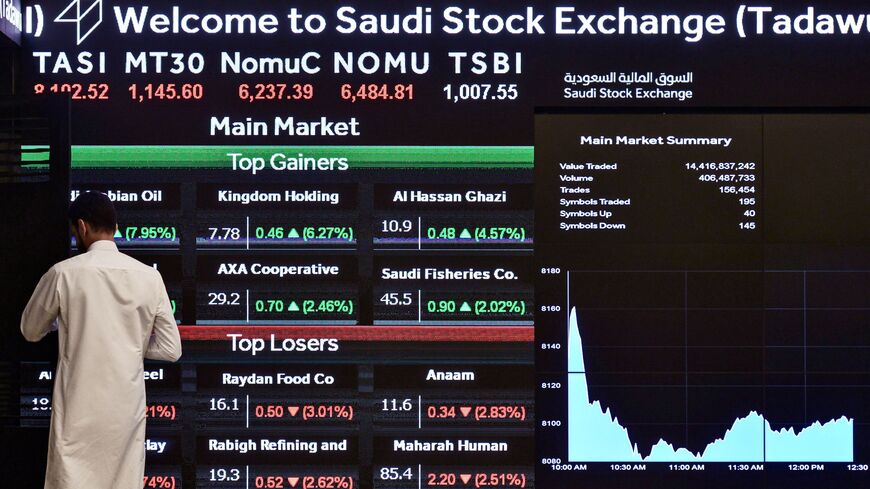 This picture taken December 12, 2019 shows a man monitoring the board at the Stock Exchange Market (Tadawul) bourse in Riyadh. - Energy giant Saudi Aramco's market value soared above $2 trillion as its share price surged again on its second day of trading. The valuation milestone was sought by Saudi Crown Prince Mohammed bin Salman when he first floated the idea of selling up to five percent of Aramco, the world's largest oil firm, about four years ago. Aramco shares jumped another 9.7 percent to 38.60 riya
