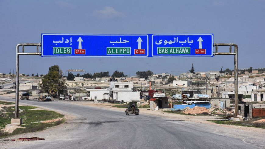 Syrians drive in the town of Saraqeb along the main Damascus-Aleppo (M5) highway in Syria's northwestern Idlib province on March 7, 2020, following a Russian-Turkish cease-fire deal. 