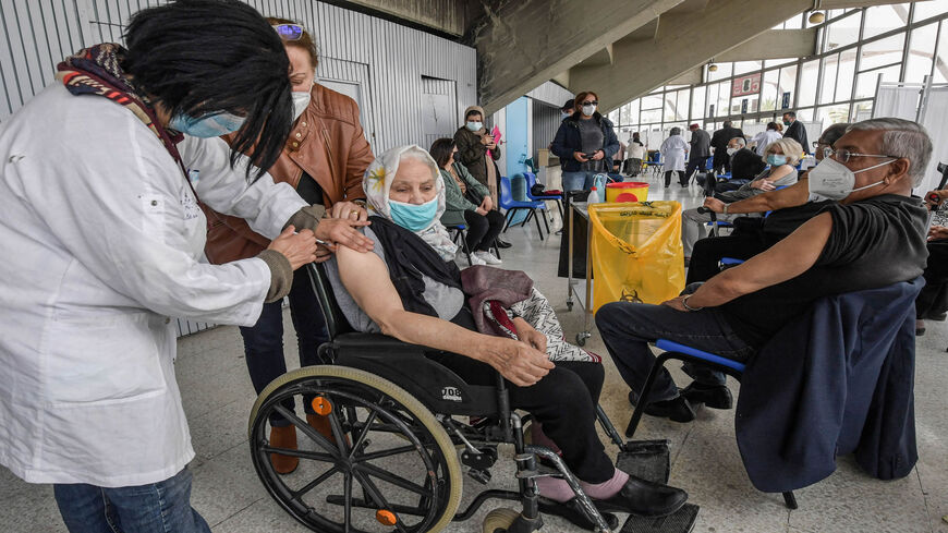 An elderly wheelchair-bound woman receives a dose of the Pfizer-BioNTech coronavirus vaccine at El-Menzah sports hall, Tunis, Tunisia, April 12, 2021.