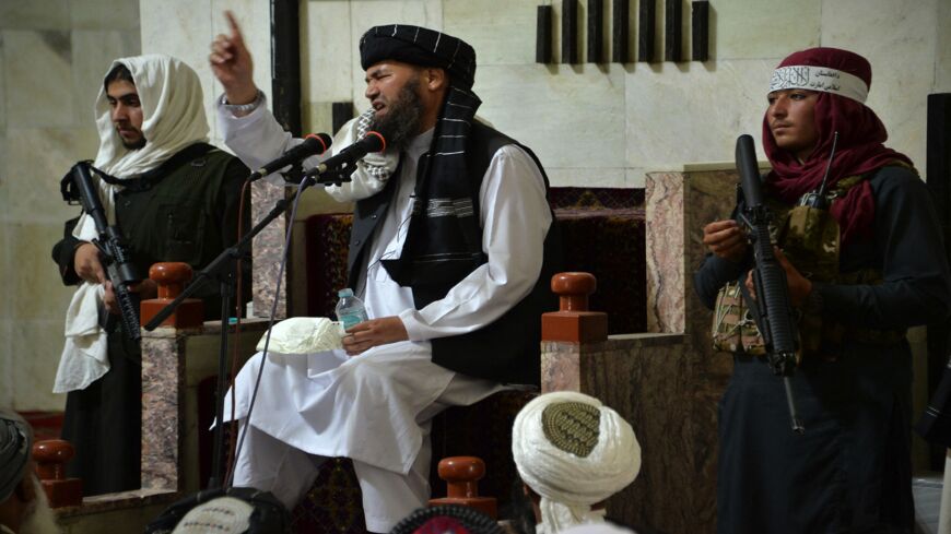 Armed Taliban fighters stand next to a mullah, a religious leader, speaking during Friday prayers at the Pul-e Khishti Mosque in Kabul on Sept. 3, 2021.