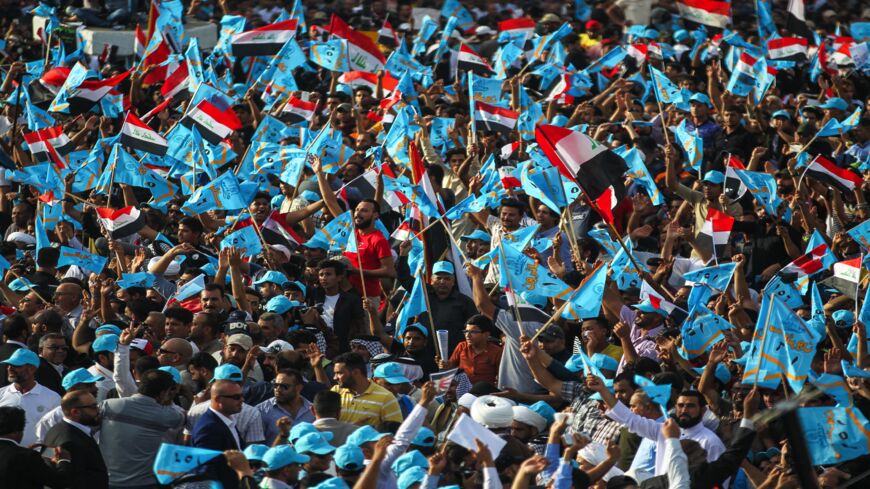 Iraqi supporters of Shiite leader Muqtada al-Sadr raise flags of their "Marching Toward Reform" electoral alliance during a campaign rally in the capital, Baghdad, on May 4, 2018.