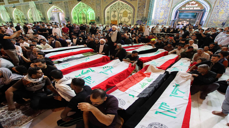 Mourners surround the caskets of victims of yesterday's attack on the village of al-Rashad in the eastern Diyala province that reportedly killed at least 11 people, during their funeral in the central shrine city of Najaf, Iraq, Oct. 27, 2021.