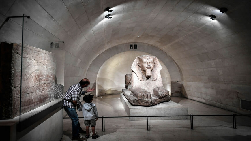 Visitors looks at a sphinx sculpture at the Egyptian department of the Louvre Museum in Paris, France, June 24, 2021.