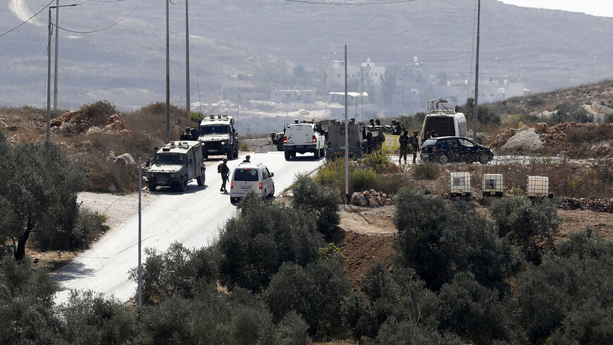 Israeli soldiers search an area for Palestinian assailants who fled after they carried out an attack on an Israeli checkpoint with an explosive device and gunfire, in the village of Till, near Nablus, West Bank, Oct. 16, 2022. 