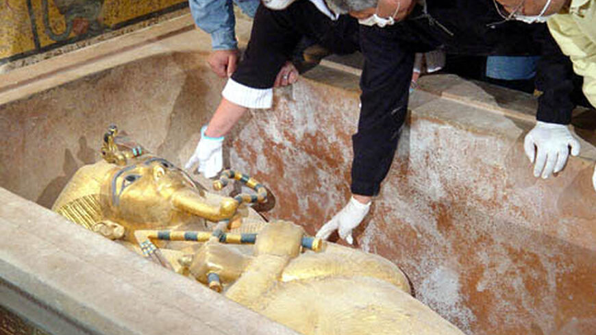 This handout photo released by Egypt's official news agency MENA shows an Egyptian archaeological team opening the solid gold sarcophagus of Pharaoh Tutankhamun to run the mummy under the computer tomography scanner, Luxor, Egypt, Jan. 5, 2005.