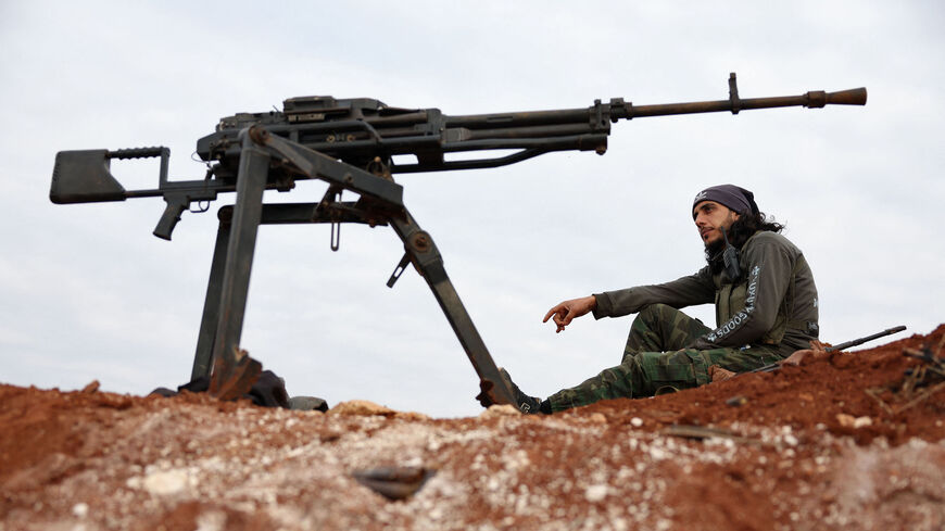 A Turkey-backed Syrian fighter sits at a position on the outskirts of the town of Marea.