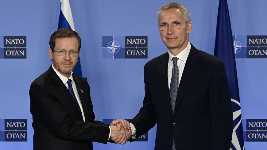 NATO Secretary General Jens Stoltenberg (R) shakes hands with President of the State of Israel Isaac Herzog.