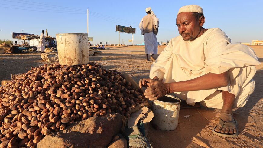 This picture taken on March 28, 2023 shows a vendor selling dates in the area of Multaqa in Sudan's Northern State, during the Muslim holy fasting month of Ramadan. - Muslims follow the tradition set by the prophet Mohammed whom believers say used to break his fast by eating dates and drinking goat's milk during the fasting month. The dawn-to-dusk fast is conceived as a spiritual struggle against the seduction of earthly pleasures, but the evening iftar festive meals traditionally bring families together du