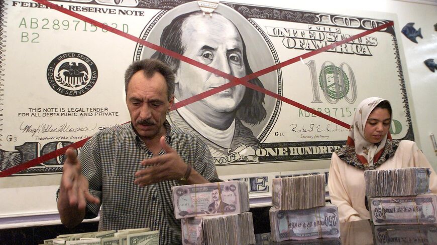 Two bank employees count dollars and Iraqi dinars in Baghdad on Sept. 28, 2000.