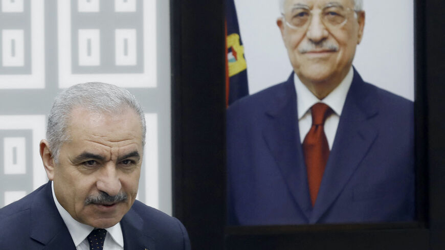 Palestinian Prime Minister Mohammad Shtayyeh stands next to a portrait of the Palestinian Authority's President Mahmud Abbas during a cabinet meeting in which he announced his government's resignation and called for "new political measures" in Ramallah on Feb. 26, 2024, amid the ongoing war in the Gaza Strip. 