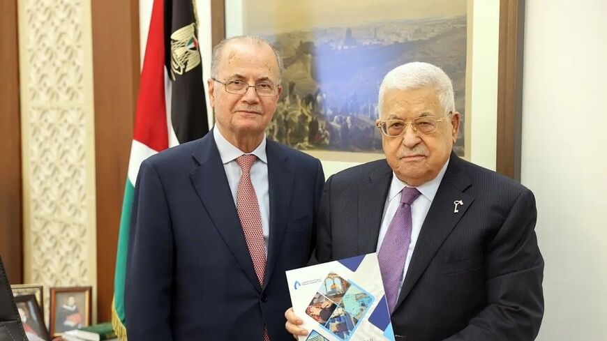 Former Chairman of the Palestine Investment Fund Mohammad Mustafa (L) poses for a photo with Palestinian President Mahmoud Abbas.