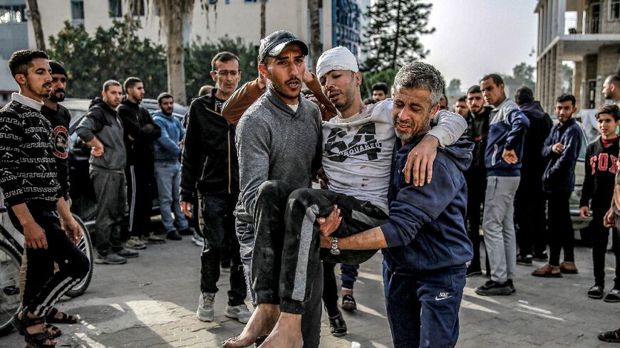 An injured man is helped outside Ahli Arab hospital in Gaza City -- the United Nations says the Gaza Strip's health system is collapsing