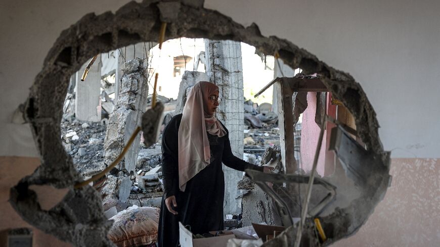 A Palestinian woman checks the rubble of a home hit by Israeli bombing in the southernmost Gaza city of Rafah