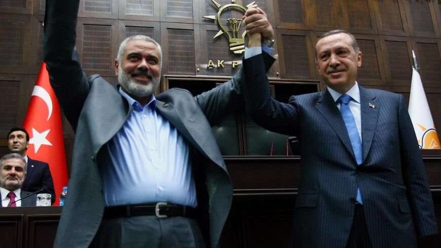 Hamas leader Ismail Haniyeh (L) and Turkish Prime Minister Recep Tayyip Erdogan salute the lawmakers of Erdogan's Justice and Development Party at the parliament in Ankara, Jan. 3, 2012. 