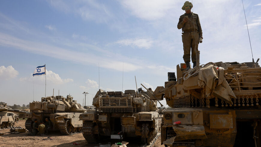 An Israeli soldier checks a mobile atop a tank in a army camp near Israel's border with the Gaza Strip on April 8, 2024, amid the ongoing conflict between Israel and the militant group Hamas. (Photo by Menahem Kahana / AFP) (Photo by MENAHEM KAHANA/AFP via Getty Images)