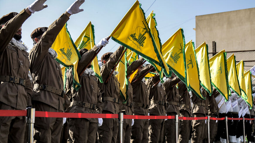 Hezbollah members salute and raise the group's yellow flags during the funeral of their fallen comrades Ismail Baz and Mohamad Hussein Shohury, who were killed in an Israeli strike on their vehicles, in Shehabiya in south Lebanon on April 17, 2024. (Photo by AFP) (Photo by -/AFP via Getty Images)