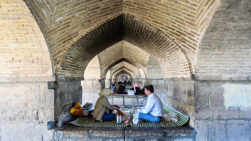 People picnic under the Si-o-Se Pol Bridge in Isfahan after the reported explosions
