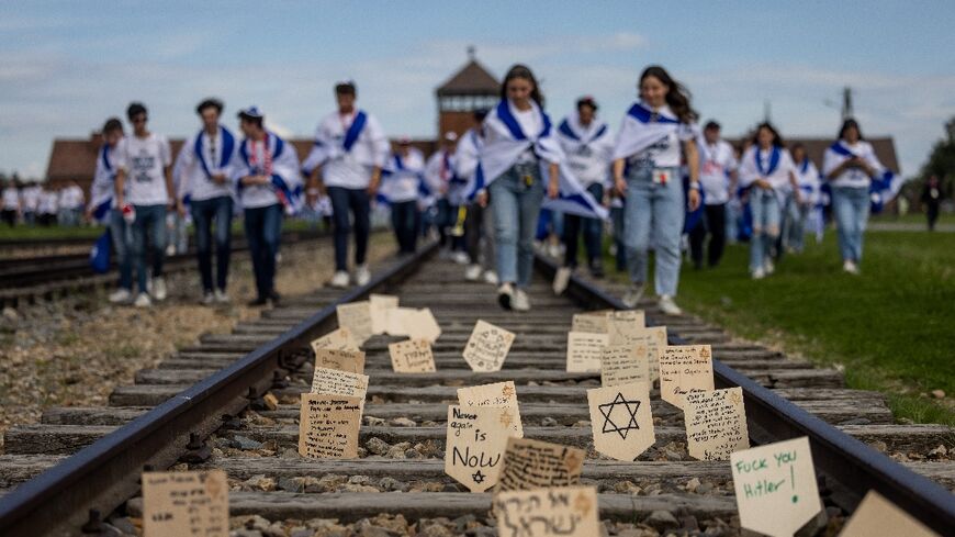 Wooden plaques with messages and prayers placed on the railway to the former Auschwitz-Birkenau death camp
