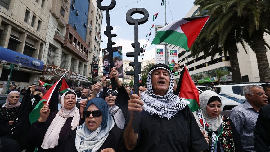 Palestinian protesters hold symbolic keys during a rally in the northern West Bank city of Nablus 