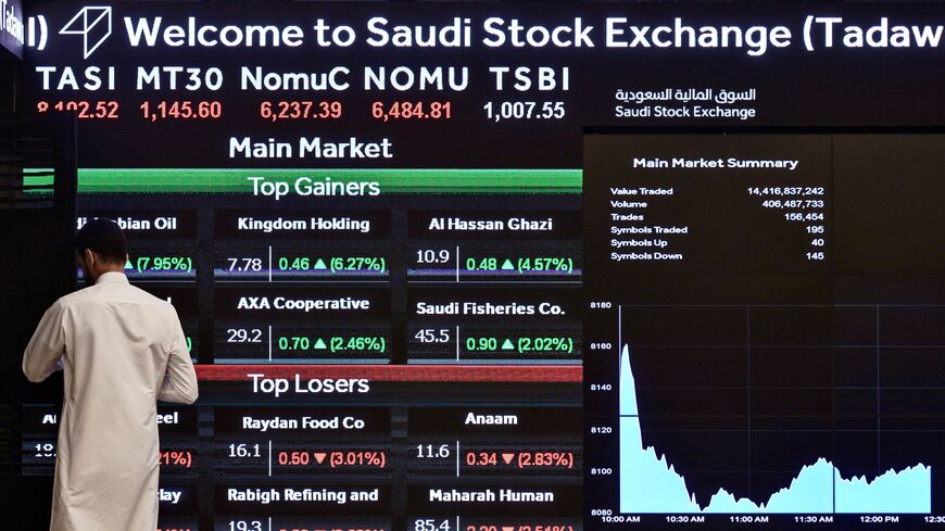 This picture shows a man monitoring the board at the Saudi Stock Exchange Market (Tadawul) bourse in Riyadh, on Dec. 12, 2019.