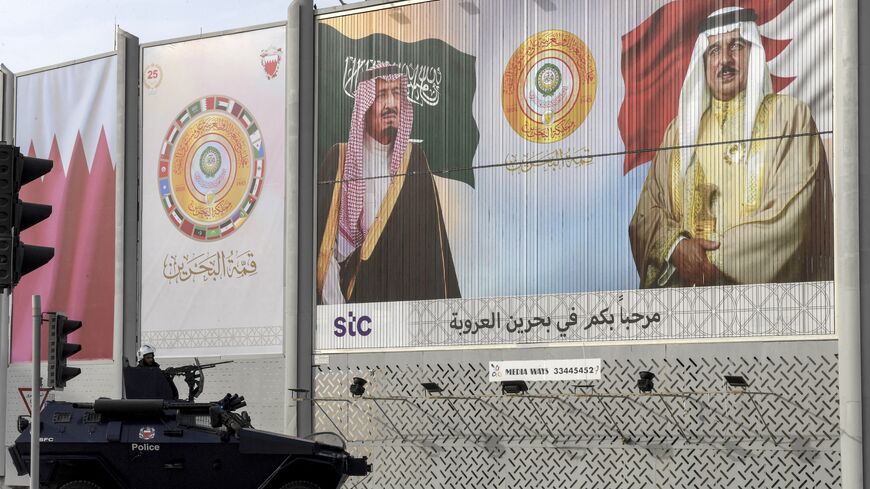 A Bahrain security forces armored vehicle is stationed near a billboard depicting the faces of Saudi Arabia's King Salman bin Abdulaziz (L), last year's Arab League summit host, and Bahrain's King Hamad bin Isa Al Khalifa (R), this year's host,  ahead of the 33rd league summit in Manama, May 15, 2024. 
