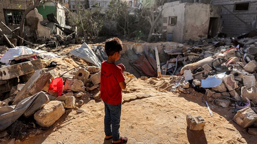 A boy stands before a crater where a   building hit by Israeli bombardment in Rafah once stood