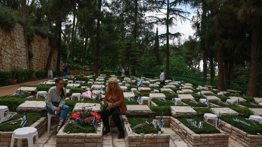 Israelis visit the graves of fallen soldiers at Jerusalem's Mount Herzl military cemetery on the eve of Memorial Day