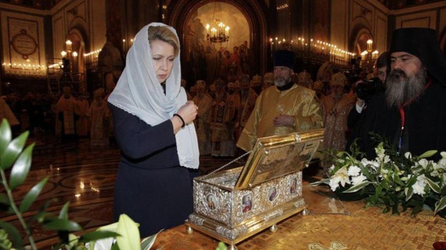 Russia's First Lady Svetlana Medvedeva (L front) crosses herself in front of a chest containing the Cincture of the Virgin Mary during a service at the Cathedral of Christ the Saviour in Moscow November 19, 2011. Orthodox Christians believe that one can be cured from serious diseases by touching the holy relic. According to legend, the holy relic was a belt made from camel wool by the Virgin Mary, and was part of her dress. The holy relic was brought to Russia from Vatopedi monastery in Greece, and has trav
