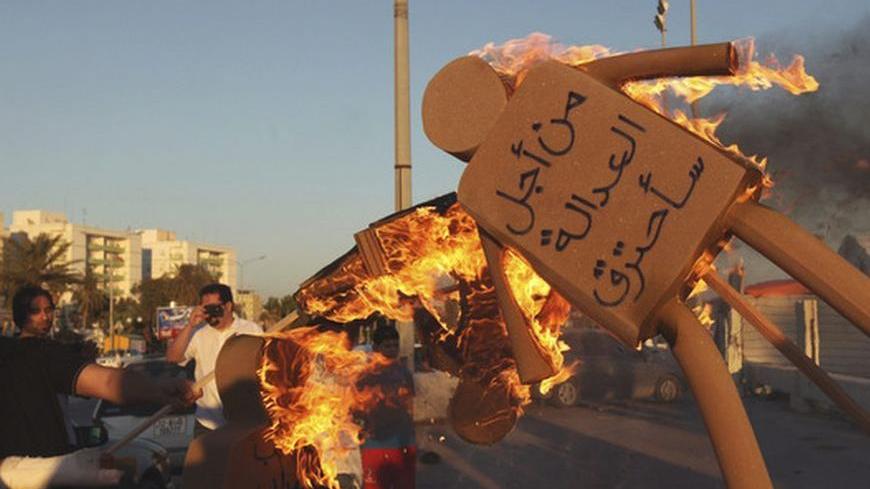 Men set fire to sponge dolls, representing the demonstrators' rejection of the current allocation of seats in the elections for Libya's National Congress, during a protest in Benghazi June 9, 2012. The words on the doll on the right read: "For justice will be burned".   REUTERS/Esam Al-Fetori    (LIBYA - Tags: POLITICS CIVIL UNREST TPX IMAGES OF THE DAY ELECTIONS)