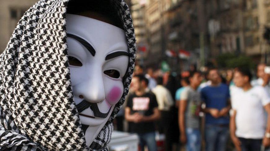 A protester wearing a Guy Fawkes mask attends a demonstration against presidential candidates Mohamed Mursi and Ahmed Shafiq at Tahrir Square in Cairo May 29, 2012. Several thousand protesters took to the streets across Egypt to demonstrate after the first-round result - a run-off between Shafiq and the Muslim Brotherhood's Mohamed Mursi, two of the most controversial figures in the field. REUTERS/Mohammed Salem (EGYPT - Tags: POLITICS ELECTIONS)