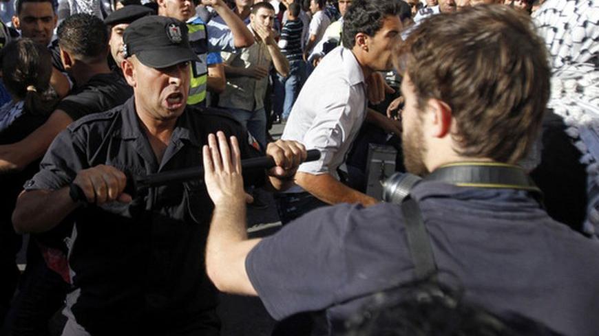 A member of the Palestinian security forces scuffles with a journalist in the West Bank city of Ramallah July 1, 2012, during a protest by Palestinians against a meeting between President Mahmoud Abbas and Israeli Vice Premier Shaul Mofaz that had been put off. Abbas has postponed the controversial meeting with Mofaz that had been scheduled for Sunday, Palestinian officials said on Saturday. REUTERS/Mohamad Torokman (WEST BANK - Tags: POLITICS CIVIL UNREST)