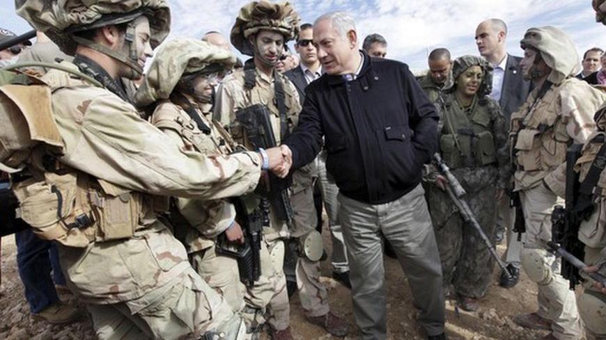 Israel's Prime Minister Benjamin Netanyahu (C) meets with soldiers from the Israeli Defence Force (IDF) during a tour of the Israel and Egypt border in southern Israel January 21, 2010. 
REUTERS/Ariel Jerozolimsk/Pool (ISRAEL - Tags: MILITARY POLITICS)