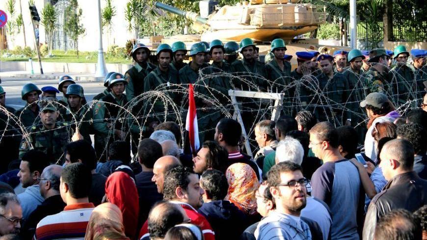 Barbed wire erected by Egypt's republican guards separates between soldiers and protesters who chanted against the constitutional referendum scheduled on Saturday Dec. 15.