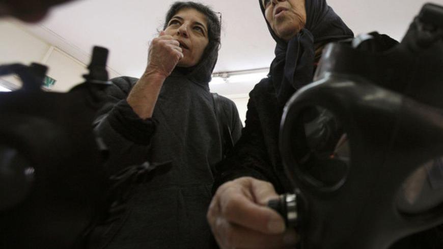 Women listen to an explanation at a gas mask distribution centre in a post office in Or Yehuda, near Tel Aviv March 3, 2010. Israel began a nationwide drive to distribute gas 
masks to its citizens on Sunday. The timing is not related to 
any emergency situation and the decision on distribution was made a year ago, a spokeswoman for the Israeli Postal Authority, responsible for the drive, said. REUTERS/Gil Cohen Magen (ISRAEL - Tags: POLITICS MILITARY)