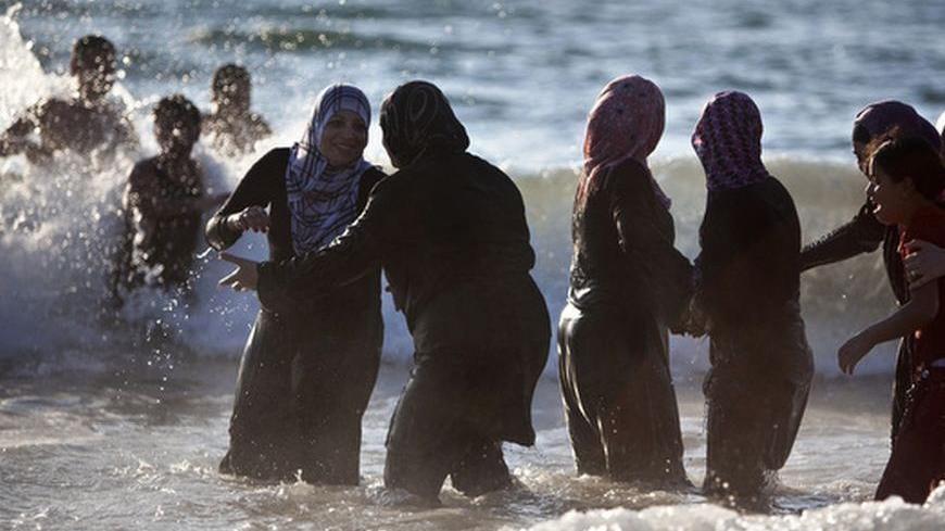 Palestinian women enjoy themselves at a beach in Tel Aviv during Eid al-Fitr, which marks the end of the holy month of Ramadan August 20, 2012. A spokesperson for The Israeli Coordinator for Government Activities in the Territories' (COGAT) said that improved security had allowed for the entry of over 1 million Palestinians from the occupied West Bank since the beginning of Ramadan. REUTERS/Nir Elias (ISRAEL - Tags: RELIGION SOCIETY)