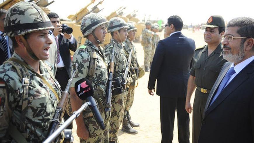 Egypt's President Mohamed Mursi (R) and Egypt's Defence Minister Abdel Fattah al-Sisi (2nd R) greet soldiers during his visit to the 6th armoured division of the second army, near Ismailia, some 75 miles (121 km) north of Cairo October 10, 2012. Picture taken October 10, 2012.  REUTERS/Egyptian Presidency/Handout (EGYPT - Tags: POLITICS MILITARY) FOR EDITORIAL USE ONLY. NOT FOR SALE FOR MARKETING OR ADVERTISING CAMPAIGNS. THIS IMAGE HAS BEEN SUPPLIED BY A THIRD PARTY. IT IS DISTRIBUTED, EXACTLY AS RECEIVED 