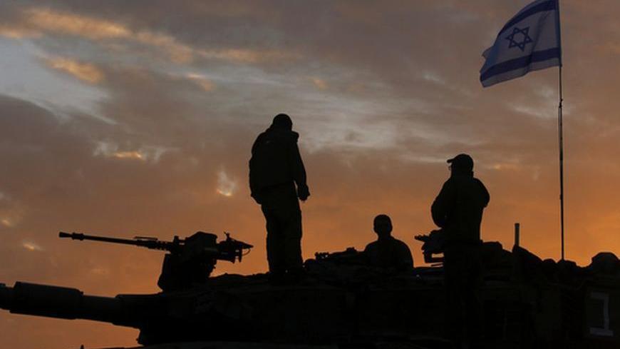 Israeli soldiers, atop a tank, prepare to leave their Gaza border position at sun rise November 22, 2012. A ceasefire between Israel and Gaza's Hamas rulers took hold on Thursday after eight days of conflict, although deep mistrust on both sides cast doubt on how long the Egyptian-sponsored deal can last.  REUTERS/Yannis Behrakis (ISRAEL - Tags: CONFLICT POLITICS)