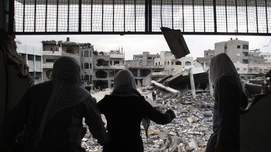 Palestinian school girls look at destroyed buildings from their school, which witnesses said was damaged in an Israeli air strike, in Gaza City November 24, 2012. Israel eased restrictions on Gaza fishermen on Saturday, further implementing a three-day-old truce brokered by Egypt after a week of fierce fighting, Palestinian officials said. Hundreds of thousands of Palestinian children headed back to school for the first time in 10 days, in another indication normal life was returning after cross-border viol