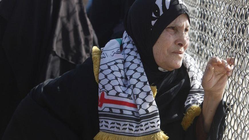A Palestinian woman waits for the return of Fatah movement activists at the Rafah border crossing in the southern Gaza Strip December 3, 2012. The Islamist Hamas group allowed the 10 activists of Palestinian President Mahmoud Abbas' Fatah movement, who fled Gaza into Egypt in 2007 during internal fighting between the two political rivals, to return home in what the group said was a sign of rapprochement, according to a Hamas official.  REUTERS/Ibraheem Abu Mustafa (GAZA - Tags: POLITICS CIVIL UNREST)