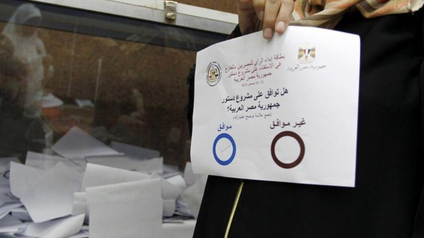 An Egyptian woman shows her vote on the new Egyptian constitution at the Egyptian consulate in Dubai, December 12, 2012. Egyptians abroad went to embassies on Wednesday to vote in a referendum on the new constitution that President Mohamed Mursi fast-tracked through an Islamist-led drafting assembly, drawing the ire of the opposition. REUTERS/Jumana El Heloueh (UNITED ARAB EMIRATES - Tags: POLITICS)