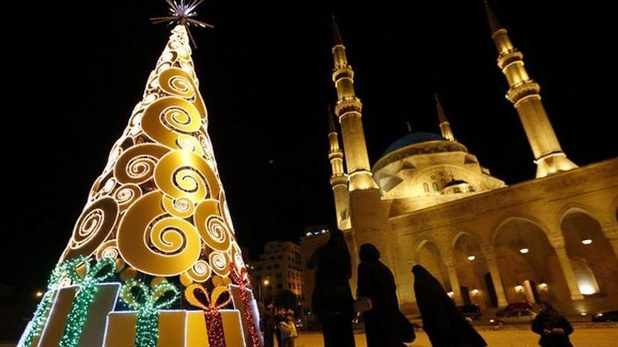 Residents stand near a Christmas tree in front of the Al-Amin mosque in downtown Beirut December 18, 2012. REUTERS/Jamal Saidi (LEBANON - Tags: RELIGION SOCIETY)