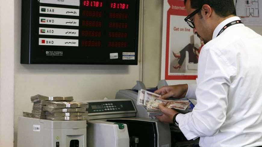 An employee counts money in a bank in Cairo, August 27, 2012. Demand for the Egyptian central bank's repurchasing agreement (repo) facility has fallen back after shooting up in June, indicating that short-term pressure on the banking system may be easing as more money flows into the country. The government introduced the facility in March last year to boost liquidity in Egypt's turbulent financial markets a month after President Hosni Mubarak resigned in the wake of a popular uprising. Picture Taken August 