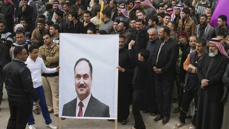 Protesters hold a poster of Iraq's Finance Minister Rafaie Esawi during a demonstration calling for Prime Minister Nuri al-Maliki's resignation, in Falluja, a main city in the western desert province of Anbar, 50 km (30 miles) west of Baghdad December 21, 2012. Sunni leaders in Iraq accused Shi'ite Prime Minister Maliki of a crackdown on Friday after troops detained a Sunni minister's bodyguards, setting off protests in one province and threatening to reignite a political crisis. Several thousand demonstrat