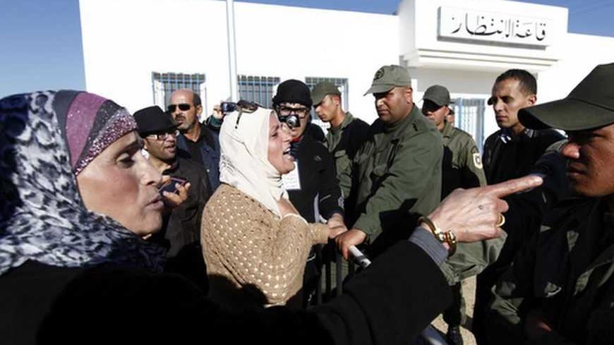 A Tunisian protester gestures towards a police officer during a demonstration outside Mornaguia jail calling for the liberation of Sami Fehri, TV producer and director of Ettounsiya Television, in Tunis December 24, 2012. REUTERS/Anis Mili  (TUNISIA - Tags: POLITICS CIVIL UNREST SOCIETY)