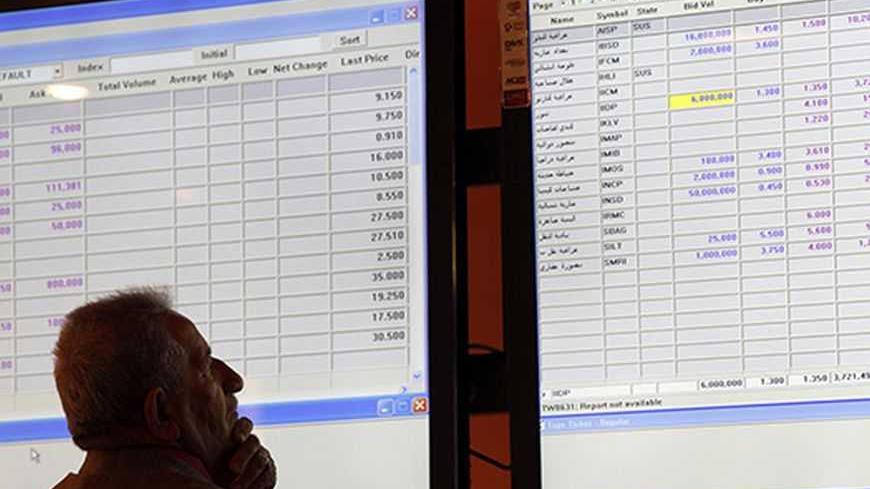 An investor monitors share prices on an electronic board at the Iraq Stock Exchange (ISX) in Baghdad , January 7, 2013. REUTERS/Mohammed Ameen (IRAQ - Tags - Tags: BUSINESS)