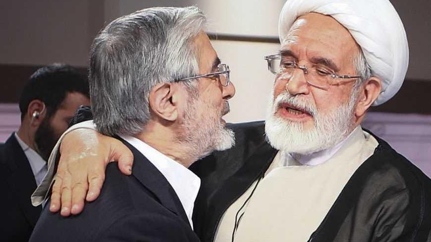 Iran's presidential election candidates Mehdi Karoubi (R) and Mirhossein Mousavi embrace after a TV debate in Tehran June 7, 2009. Iranians vote on June 12 in an election that pits hardline President Mahmoud Ahmadinejad against two moderate challengers and one fellow conservative. REUTERS/IRIB (IRAN POLITICS ELECTIONS) - RTR24F76