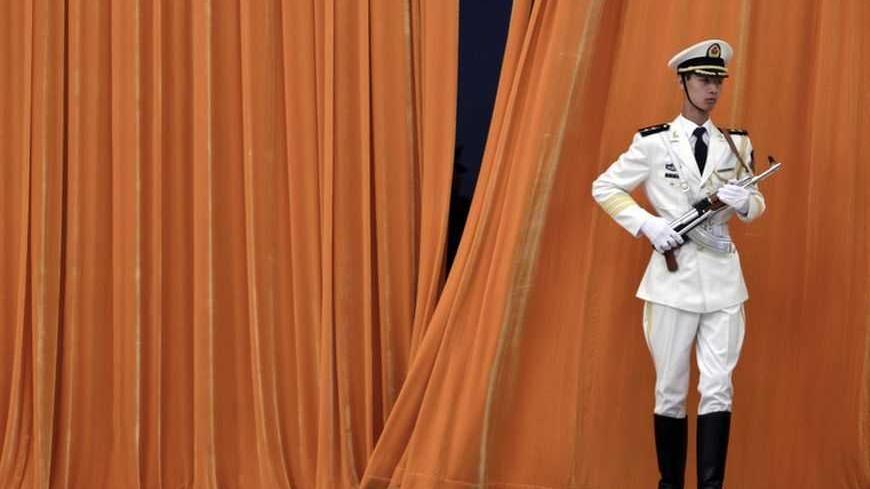 A soldier stands in front of a curtain ahead of a welcoming ceremony for the Shanghai Cooperation Organisation summit at the Great Hall of the People in Beijing June 8, 2012. REUTERS/Jason Lee (CHINA - Tags: MILITARY POLITICS) - RTR339LB