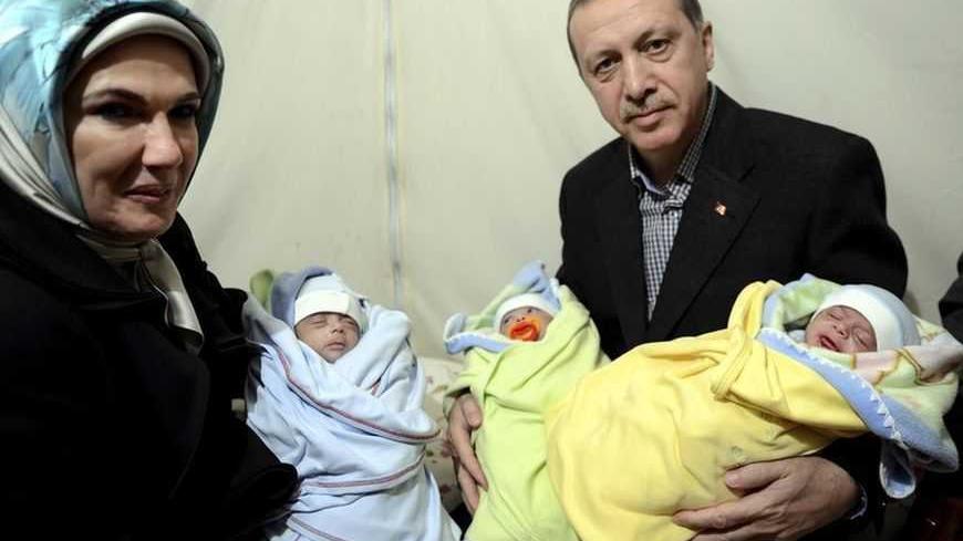 Turkish Prime Minister Tayyip Erdogan and his wife Emine Erdogan pose with Syrian refugee triplet brothers whose names are Recep, Tayyip and Erdogan as they visit a refugee camp near Akcakale border crossing on the Turkish-Syrian border, southern Sanliurfa province, December 30, 2012. REUTERS/Kayhan Ozer/Prime Minister's Press Office/Handout (TURKEY  - Tags: POLITICS CONFLICT) ) FOR EDITORIAL USE ONLY. NOT FOR SALE FOR MARKETING OR ADVERTISING CAMPAIGNS. THIS IMAGE HAS BEEN SUPPLIED BY A THIRD PARTY. IT IS 