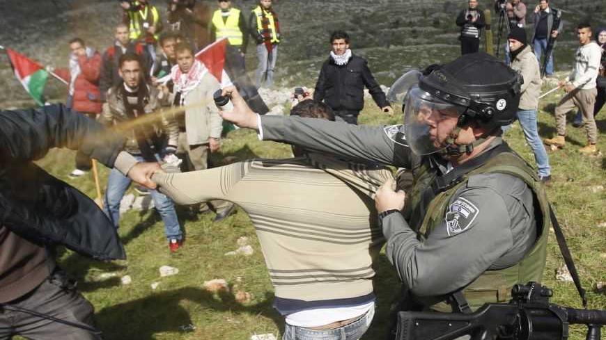 An Israeli border police officer uses pepper spray to disperse Palestinian activists after the group set up tents and makeshift structures in protest against a nearby Jewish settlement in the West Bank village of Burin, south of Nablus February 2, 2013. Palestinians who set up a makeshift encampment in the occupied West Bank on Saturday clashed with Israeli soldiers and settlers and some light injuries were sustained.
REUTERS/Mohamad Torokman (WEST BANK - Tags: POLITICS RELIGION CIVIL UNREST TPX IMAGES OF T